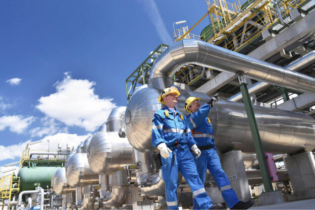 Two Oilfield Workers Inspecting Oil Refinery